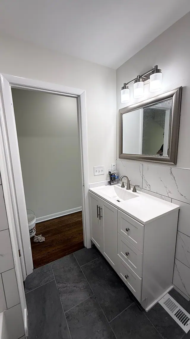 Bathroom remodel with white vanity and gray flooring by Grain and Stain Renovations in Hendersonville TN