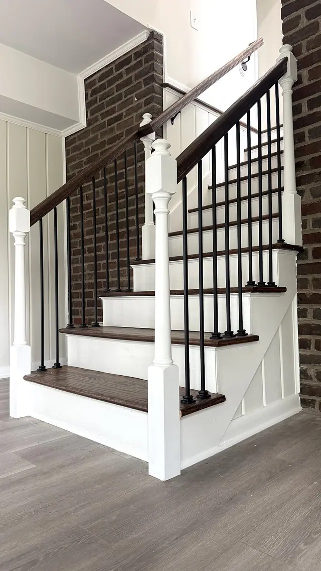 Dark stained stair treads with black railing and white trim by Grain and Stain Renovations in Hendersonville TN