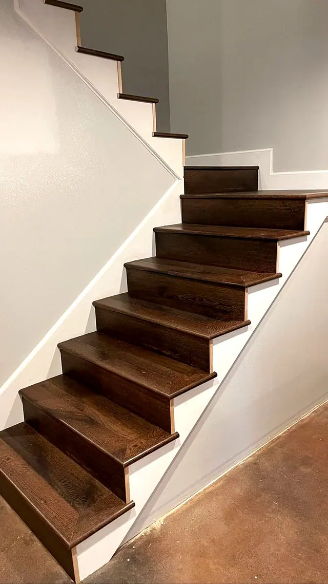 Dark stained wood staircase with white risers by Grain and Stain Renovations in Hendersonville TN