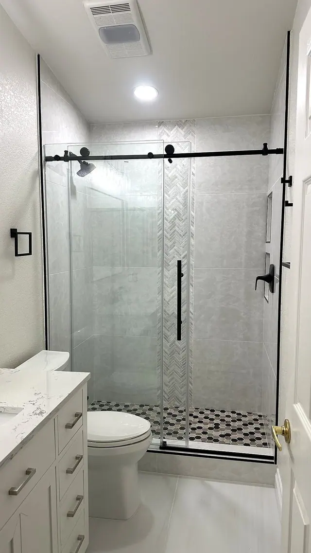 Frameless glass shower remodel with white tile and black hardware by Grain and Stain Renovations in Hendersonville TN