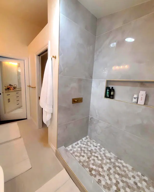 Gray tile shower remodel with pebble floor and niche by Grain and Stain Renovations in Hendersonville TN