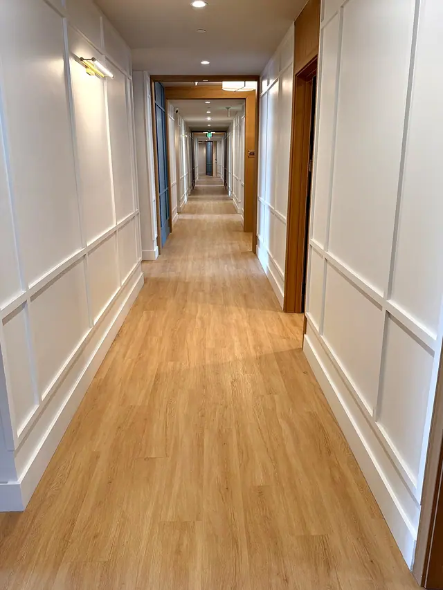 Hallway finish carpentry with white trim, wall paneling, doors, and painted walls by Grain and Stain Renovations in Hendersonville TN