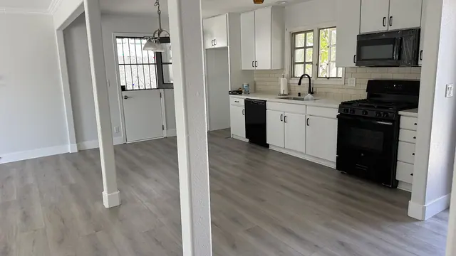 Kitchen with gray LVP flooring and white cabinets by Grain and Stain Renovations in Hendersonville TN