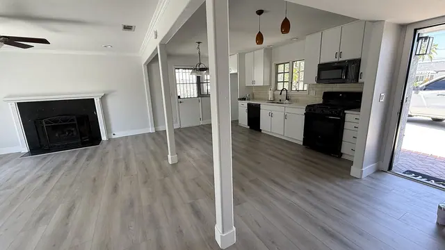 Open concept kitchen and living room with gray LVP flooring by Grain and Stain Renovations in Hendersonville TN