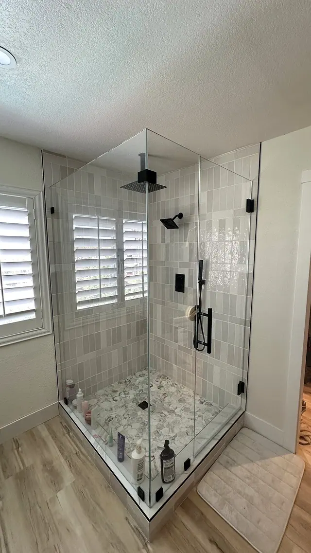 Walk in shower remodel with white tile black fixtures and glass by Grain and Stain Renovations in Hendersonville TN