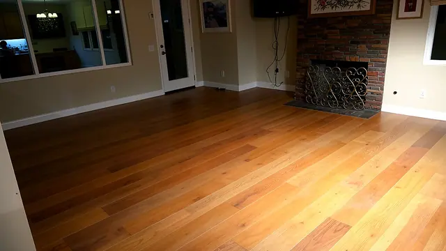 Warm hardwood flooring in living room with brick fireplace by Grain and Stain Renovations in Hendersonville TN