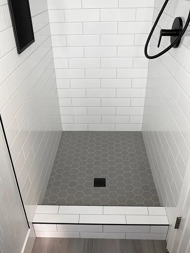 White subway tile shower with gray hex floor by Grain and Stain Renovations in Hendersonville TN